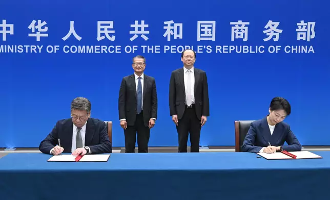 陳茂波（後排左）和國家商務部部長助理袁曉明（後排右）見證下，商務及經濟發展局局長丘應樺（前排左）與國家商務部自貿區港建設協調司司長何咏前（前排右）簽署《關於加強自貿區港交流合作的諒解備忘錄》。 政府新聞處圖片