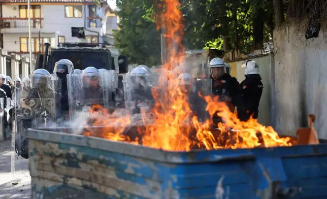 防暴警察在阿爾巴尼亞地拉那的反政府集會中，站在一個燃燒的垃圾桶後方列陣，2026年10月24日周六。(美聯社圖片/Hameraldi Agolli) AP圖片