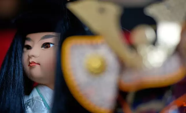 周二（2026年10月13日），東京大六天榊神社舉行玩偶紀念儀式，一個玩偶在微型武士頭盔後方展示。(美聯社圖片/Eugene Hoshiko) AP圖片