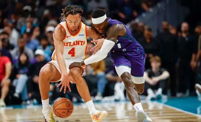 2026年10月23日周五，北卡羅來納州夏洛特，NBA籃球賽上半場，亞特蘭大鷹隊後衛京士頓費明斯（4號）與夏洛特黃蜂隊後衛丹尼斯舒路德（右）爭奪籃球。(美聯社圖片/Nell Redmond) AP圖片