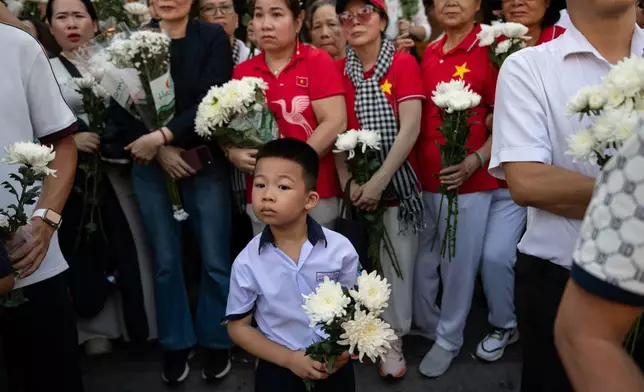 民眾圍觀731具在黎氏蓮文化公園尋獲的烈士遺骸，於2026年10月14日周三在越南胡志明市，移送至胡志明市烈士公墓安葬。(美聯社圖片/Thanh Hue) AP圖片