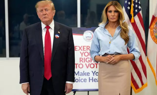 美國總統特朗普（左）與第一夫人梅拉尼婭·特朗普，2026年10月24日周六在佛羅里達州西棕櫚灘的棕櫚灘縣圖書館投下2026年中期選舉的提前選票後，聆聽記者提問。(美聯社圖片/Mark Schiefelbein) AP圖片