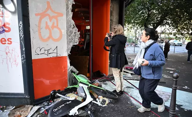 一名女子在巴黎拍攝一間被搶掠的商店，這次示威是針對生活成本上漲及學生不滿，攝於2026年10月18日周日。（美聯社圖片/Emma Da Silva） AP圖片
