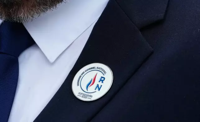 法國極右翼國民聯盟黨一名全國委員會成員，在法國奧爾良舉行的第19屆大會上佩戴徽章。攝於2026年10月25日周日。(美聯社圖片/Teresa Suarez) AP圖片