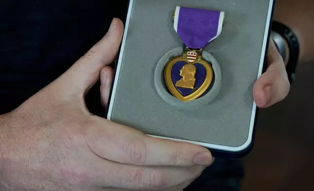陸軍中校蒂姆·哈爾伯，在科威特舒艾巴港遭伊朗無人機襲擊受傷，周四（2026年9月24日）在愛荷華州安克尼手持紫心勳章。(美聯社圖片/Charlie Neibergall) AP圖片