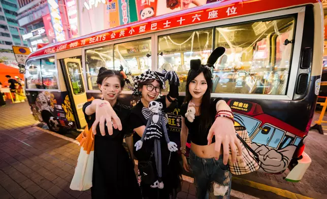 年輕市民穿上萬聖節服飾於紅VAN「旺角妖巴」前合照