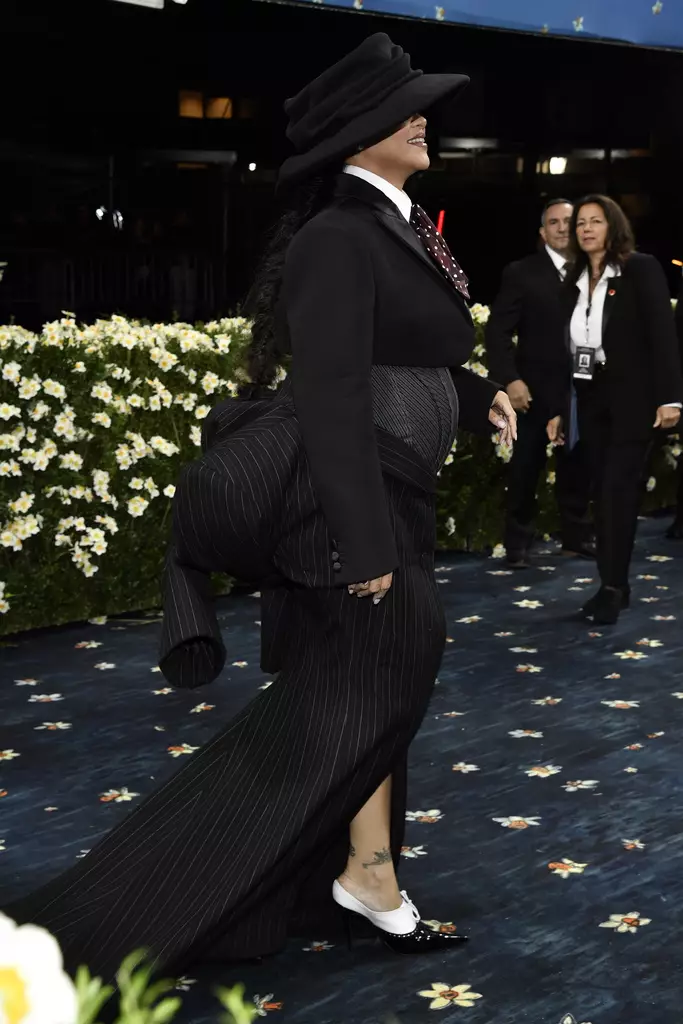 Rihanna胸前以灰色束腰馬甲勾勒孕肚曲線，下身長裙以西裝袖口綁結於腰間，充滿解構設計感。AP圖片