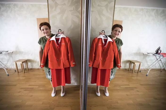 In this photo taken on Thursday, Aug. 3, 2017, Aeroflot flight attendant Yevgeniya Magurina is reflected in a mirror as she shows her uniform during an interview . (AP Photo/Alexander Zemlianichenko)