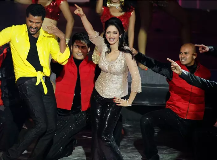 FILE - This July 6, 2013 file photo shows Bollywood actors Sridevi, center, and Prabhu Deva, left in yellow, performing during the International Indian Film Academy (IIFA) awards in Macau. Sridevi, Bollywood’s leading lady of the 1980s and ‘90s who redefined stardom for actresses in India, has died at age 54. The actress, known by one name, was described as the first female superstar in India’s male-dominated film industry. Her brother-in-law Sanjay Kapoor speaking to the Indian Express online confirmed she died Saturday, Feb. 24, 2018, in Dubai due to cardiac arrest. (AP Photo/Kin Cheung, File)