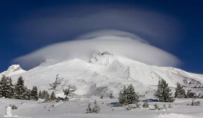 In this Dec. 14, 2009, file photo, a large cloud caps Mount Hood where the search for two missing climbers continues as seen from Timberline Lodge in Government Camp, Ore. (AP Photo/Don Ryan, File)