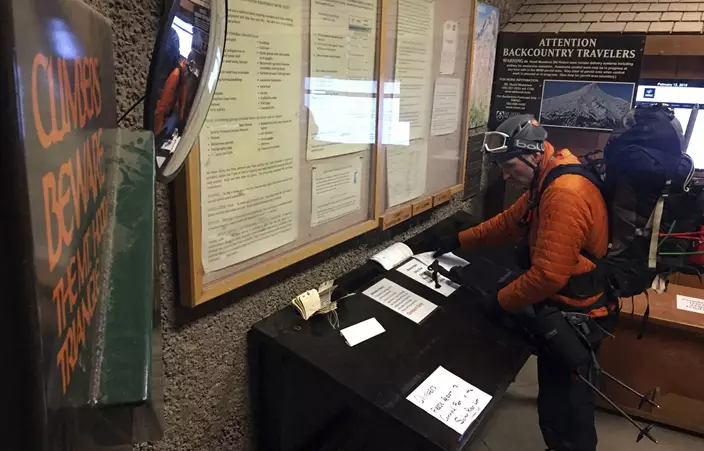 In this Tuesday, Feb. 13, 2018, photo, Scott Schoenborn, of West Linn, Ore., checks off his climbing register form at Timberline Lodge in Government Camp, Ore., after climbing Mount Hood. A fatality and an hours-long rescue effort to bring other climbers off Oregon's tallest peak as a storm approached Tuesday, Feb. 13, 2018, underscore the dangers of a mountain that's soared in popularity due to its proximity to Portland. (AP Photo/Gillian Flaccus)