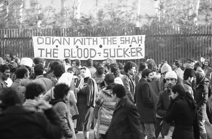 FILE - In this Jan. 13, 1979 file photo, a banner denouncing Shah Mohammad Reza Pahlavi is put up at the entrance of Tehran University in Tehran, Iran. Wednesday, Jan. 16, 2019 marks the 40th anniversary of the shah abandoning his Peacock Throne and leaving his nation for the last time in his life, setting the stage for the country's 1979 Islamic Revolution only a month later. (AP PhotoBernhard Frye, File)