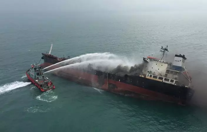 In this photo released by Hong Kong Government Flying Service, black smoke billows from an oil tanker after catching fire off southern Lamma island of Hong Kong, Tuesday, Jan. 8, 2019. Hong Kong fire officials say an oil-tanker explosion has killed one person and left three missing at sea. Authorities said Tuesday that a Vietnam-registered oil tanker burst into flames about 11:30 a.m. as it prepared to refuel at an anchorage off Hong Kong's southern coast. (Hong Kong Government Flying Service via AP)