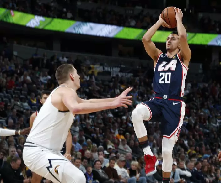 Los Angeles Clippers guard Landry Shamet, right, shoots for a basket over Denver Nuggets center Nikola Jokic in the first half of an NBA basketball game Sunday, Feb. 24, 2019, in Denver. (AP PhotoDavid Zalubowski)
