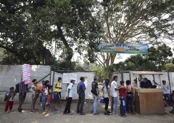 Venezuelan migrants stand in line for lunch at "Amigos Del Projimo" migrant shelter, in La Parada, on the outskirts of Cucuta, Colombia, on the border with Venezuela, Monday, Feb. 4, 2019. More than a dozen European Union countries endorsed Venezuelan opposition leader Juan Guaido as the county's interim president on Monday, piling the pressure on embattled President Nicolas Maduro to resign and clear the way for a new presidential election. (AP PhotoFernando Vergara)