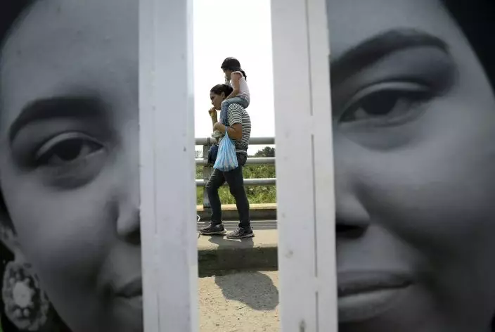 A Venezuelan woman returns to her country after buying groceries in La Parada, on the outskirts of Cucuta, Colombia, on the border with Venezuela, Monday, Feb. 4, 2019. More than a dozen European Union countries endorsed Venezuelan opposition leader Juan Guaido as the county's interim president on Monday, piling the pressure on embattled President Nicolas Maduro to resign and clear the way for a new presidential election. (AP PhotoFernando Vergara)
