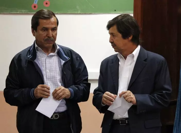 FILE - In this May 4, 2017 file photo, Algerian President Abdelaziz Bouteflika's brothers Said Bouteflika, right, and Nacer Bouteflika talk before voting in Algiers. Said Bouteflika, 61, is a top aide to his brother Abdelaziz Bouteflika, and is said to hold enormous influence in the presidential apparatus, with critics claiming he has grown rich during Bouteflika’s presidency. (AP PhotoSidali Djarboub, File)