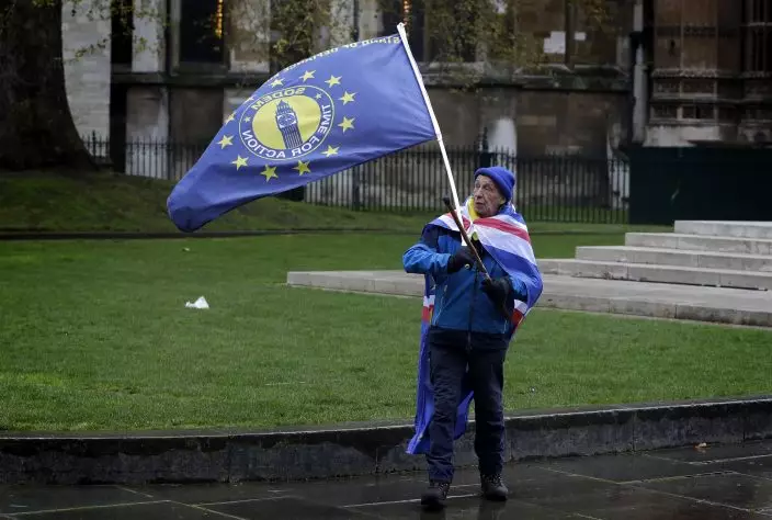 A n anti-Brexit campaigner controls his flag near parliament, in London, Tuesday, April 9, 2019. Prime Minister Theresa May has brought her case for a further delay to Britain's departure from the European Union to Berlin, while German and French officials are insisting that any extension to the deadline must come with strings attached and assurances from London. (AP PhotoKirsty Wigglesworth)