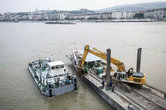 A power shovel fixed on a pontoon works in Danube river near Margaret Bridge, the scene of a boat accident, in Budapest, Hungary, Thursday, June 6, 2019. Search operations continue after a sightseeing boat carrying 33 South Korean tourists was crashed into by a large river cruise ship and sank on May 29, killing at least fifteen tourists. (Marton MonusMTI via AP)