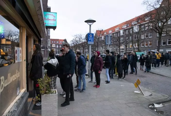 People queue to buy marijuana at coffeeshop Bulwackie in Amsterdam, Netherlands, Sunday, March 15, 2020, after a TV address of health minister Bruno Bruins who ordered all Dutch schools, cafes, restaurants, coffeeshops and sport clubs to be closed on Sunday as the government sought to prevent the further spread of coronavirus in the Netherlands. For most people, the new coronavirus causes only mild or moderate symptoms, such as fever and cough. For some, especially older adults and people with existing health problems, it can cause more severe illness, including pneumonia. (AP PhotoPeter Dejong)