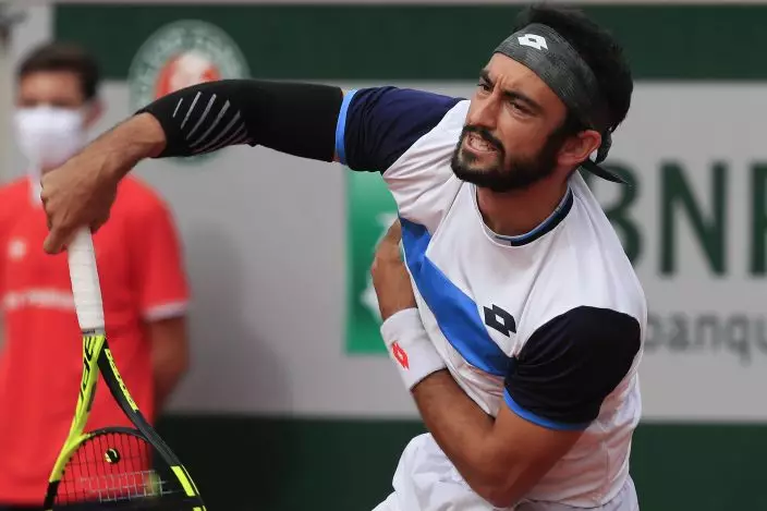 Italy's Lorenzo Giustino serves against Argentina's Diego Schwartzman in the second round match of the French Open tennis tournament at the Roland Garros stadium in Paris, France, Wednesday, Sept. 30, 2020. (AP PhotoMichel Euler)