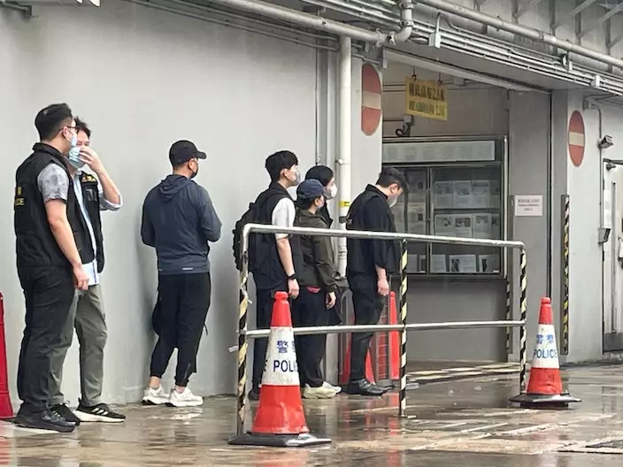 Joe Tay’s cousin (fifth from left) and her husband (third from left) escorted by Hong Kong police on May 29.