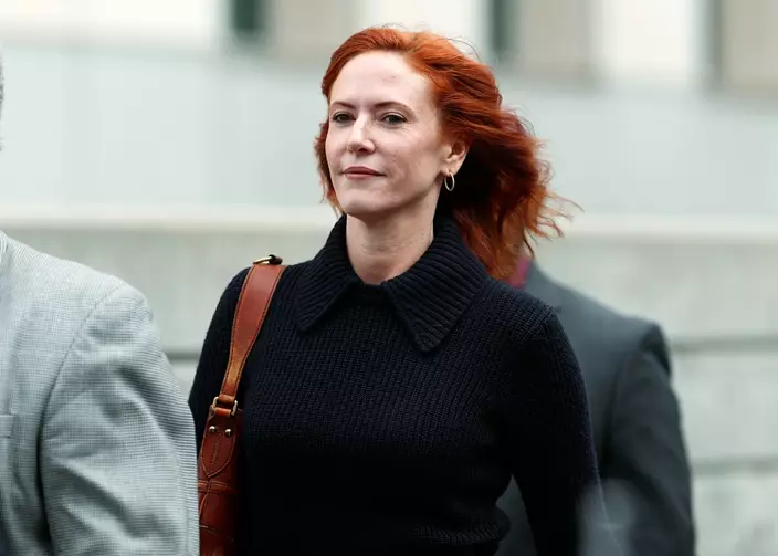 Tree Paine, publicist for pop singer Taylor Swift, is escorted from the federal courthouse after attending the fourth day in a civil trial.(AP Photo/David Zalubowski)