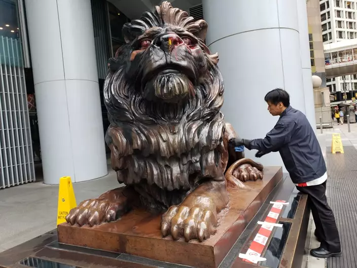 滙豐早上派人清潔銅獅子。(本網記者攝)