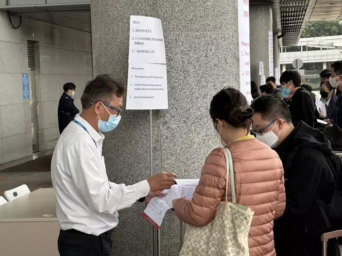 深圳灣口岸有工作人員檢查過關市民的紙本核酸。