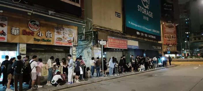 部分自由行旅客等至疲倦蹲在地上等候。