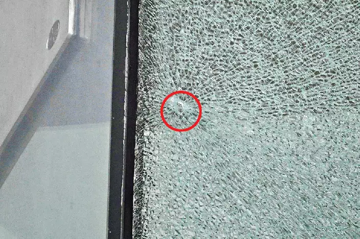 西九法院早前的玻璃幕牆疑被射擊碎裂，修路工人在行車天橋加建4米高圍欄。資料圖片
