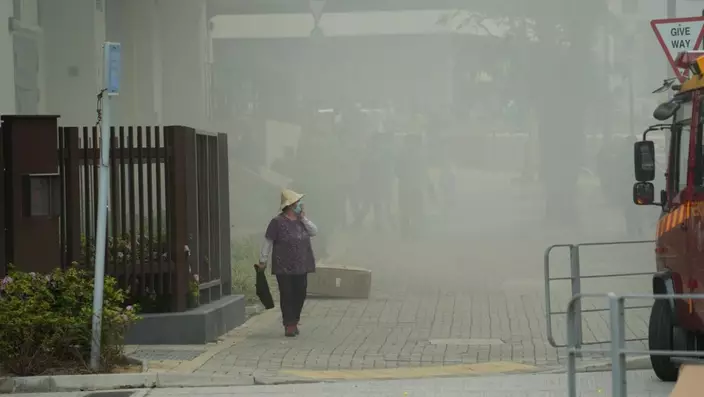 起火現場街上煙霧瀰漫，行人掩鼻而過。網上圖片
