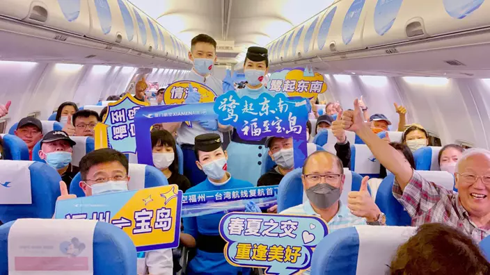 乘客乘坐福州至台北復航首航航班，與空服互動。中新社圖片