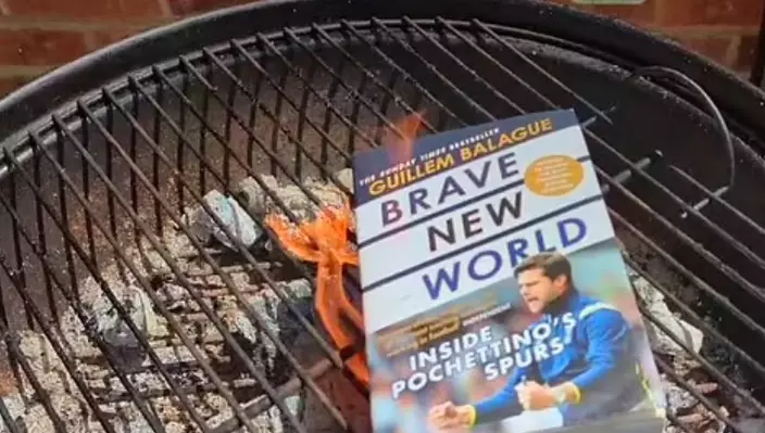 一位熱刺球迷對普捷天奴上任車路士領隊反應激烈,將一本名為《Brave New World》的書放上BBQ爐。網上圖片