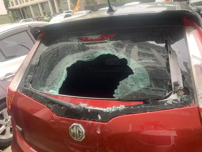 涉事的紅色私家車，後面的擋風玻璃被砸出一個大洞。（facebook圖片）