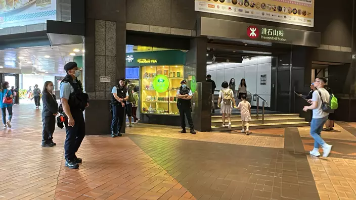 大批藍帽子全副裝備在港鐵站外巡查。