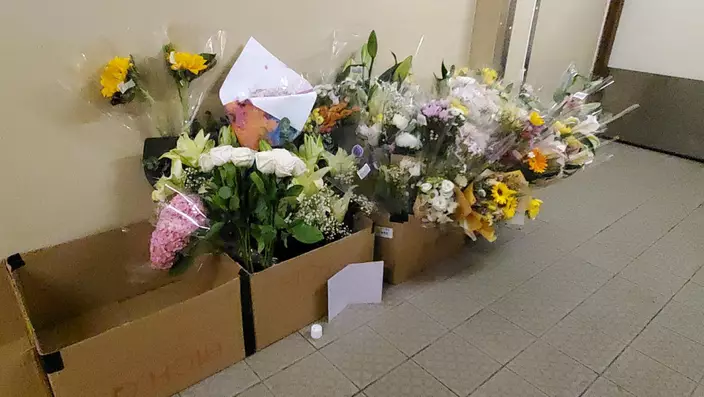 現場紙皮箱內擺滿悼念花束。