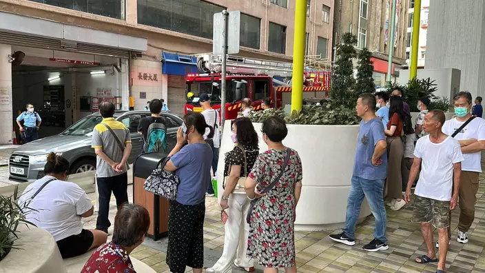 火警期間，消防要疏散十層樓的人士到街上。
