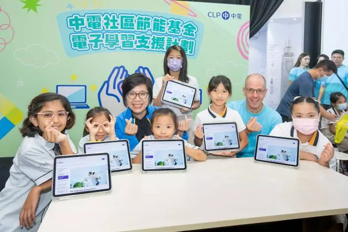 中華電力企業發展總裁莊偉茵（左三）及資訊科技高級總監貝柏安 （右二）向受惠學生派發平板電腦，並即時體驗使用全新的平板電腦。