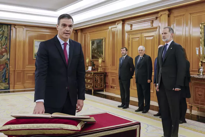 11月17日，西班牙首相桑切斯(左)在國王費利佩六世(右一)的見證下，宣誓就任。美聯社資料圖片