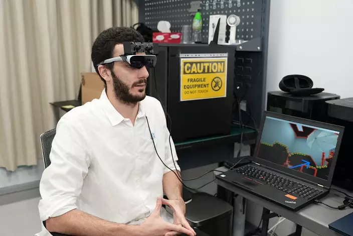 來自約旦的研究員 Nadim F. Zaro 示範戴上擴增實境（ AR ）智能助視器，助視障人士偵測障礙物及導航。