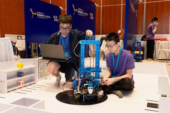 IVE電機工程高級文憑學生伍泓軼（右）與香港知專設計學院（HKDI）產品設計高級文憑畢業生吳家棟（左），組隊參與「移動機器人」項目比賽。
