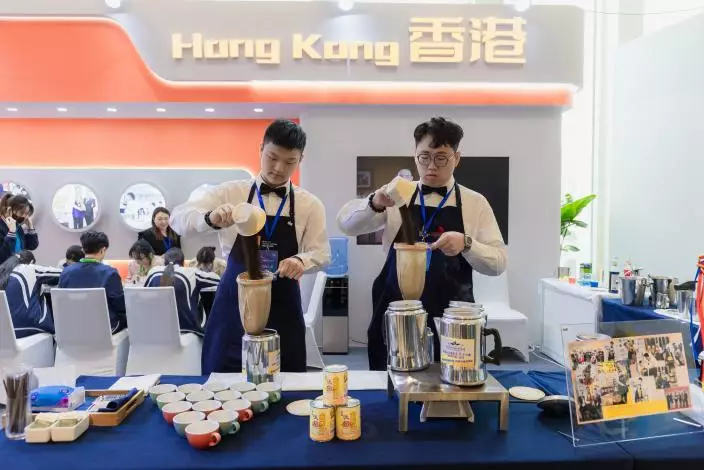 HTI餐飲營運文憑畢業生、「2023年世界技能大賽香港代表選拔賽」的「餐飲服務」項目優勝選手麥嘉俊（左）和李佳浩（右），獲邀為嘉賓沖製香醇濃滑的奶茶。