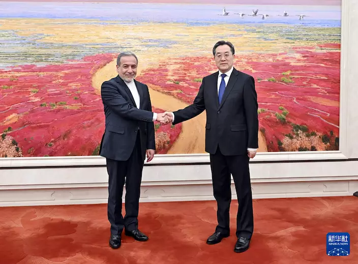 丁薛祥(右)和阿拉格齊 握手。新華社圖片