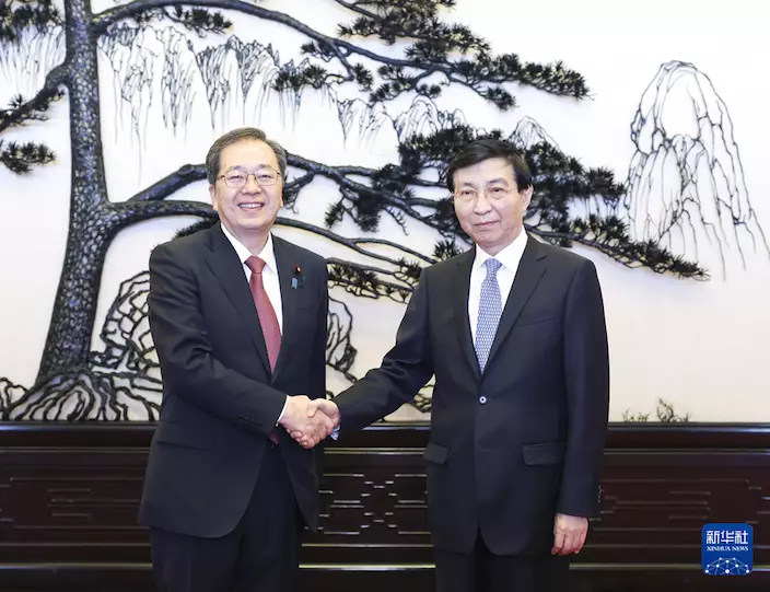王滬寧(右)會見齊藤鐵夫 。新華社圖片