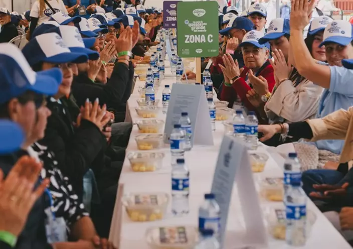哥倫比亞近1200人排排坐品嚐美味芝士破世界紀錄。Guinness World Records網站圖片
