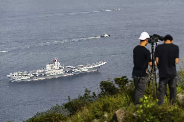 軍事愛好者登山拍攝航母進港。AP圖片