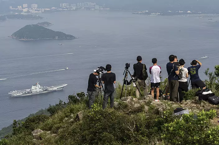 軍事愛好者登山拍攝航母進港。AP圖片