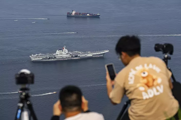 軍事愛好者登山拍攝航母進港。AP圖片