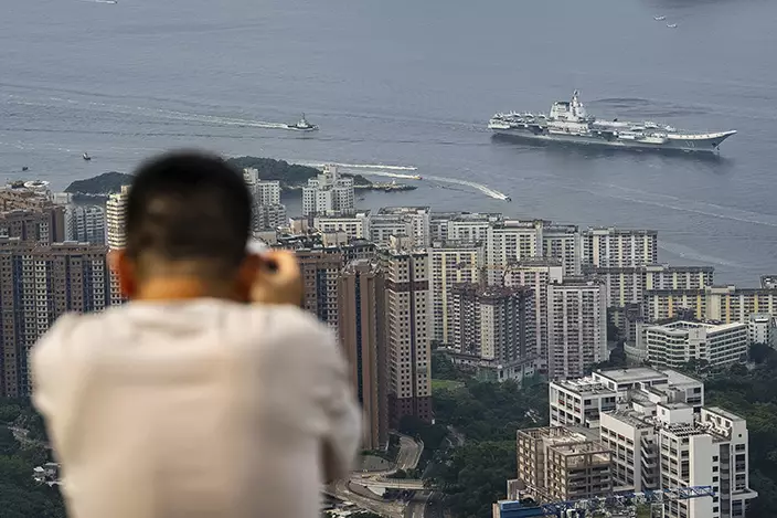 軍事愛好者登山拍攝航母進港。AP圖片